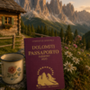 Passaporto delle Dolomiti originale Light Hunter fotografato in baita con tazza e stelle alpine, copertina classica